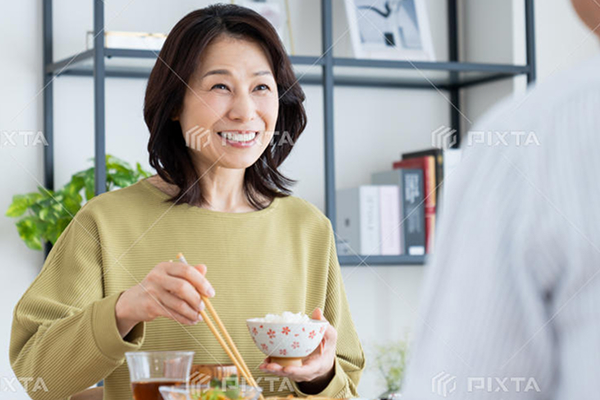 食事を味わい、笑顔で会話する女性